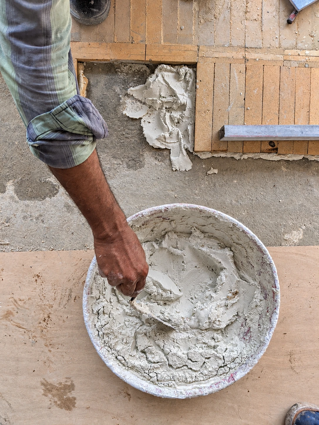 SOCIAL Vashi — Laying the brick floor. Mortar preparation and setting-out record the hands-on construction process.